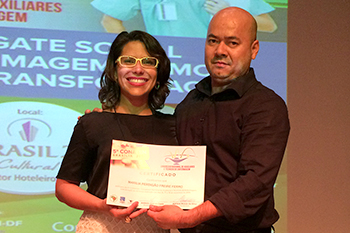 Tesoureiro do Coren-DF e coordenador do 5º Conaten, Adriano Araújo entrega certificado à enfermeira Marília Ferro